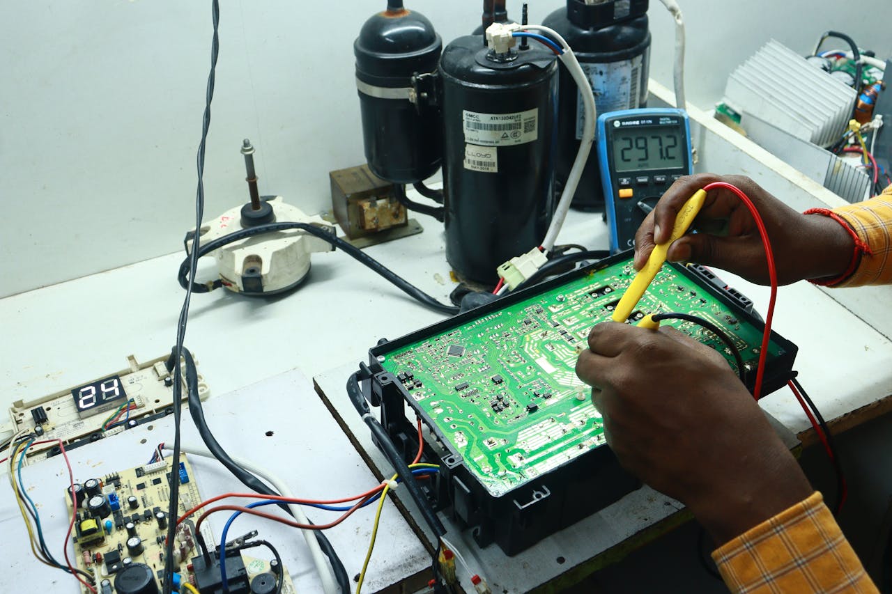 our-story-01 Technician working on AC PCB with tools and equipment, captured in New Delhi workshop.